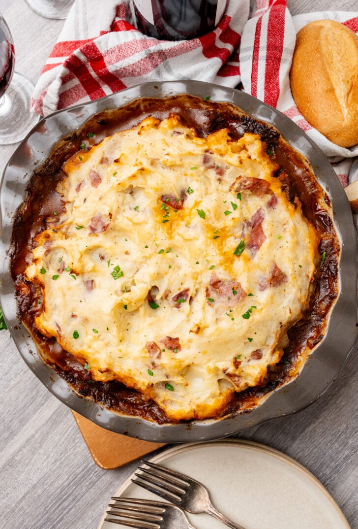 Shepherd's Pie with mashed potatoes served with bread and red wine.