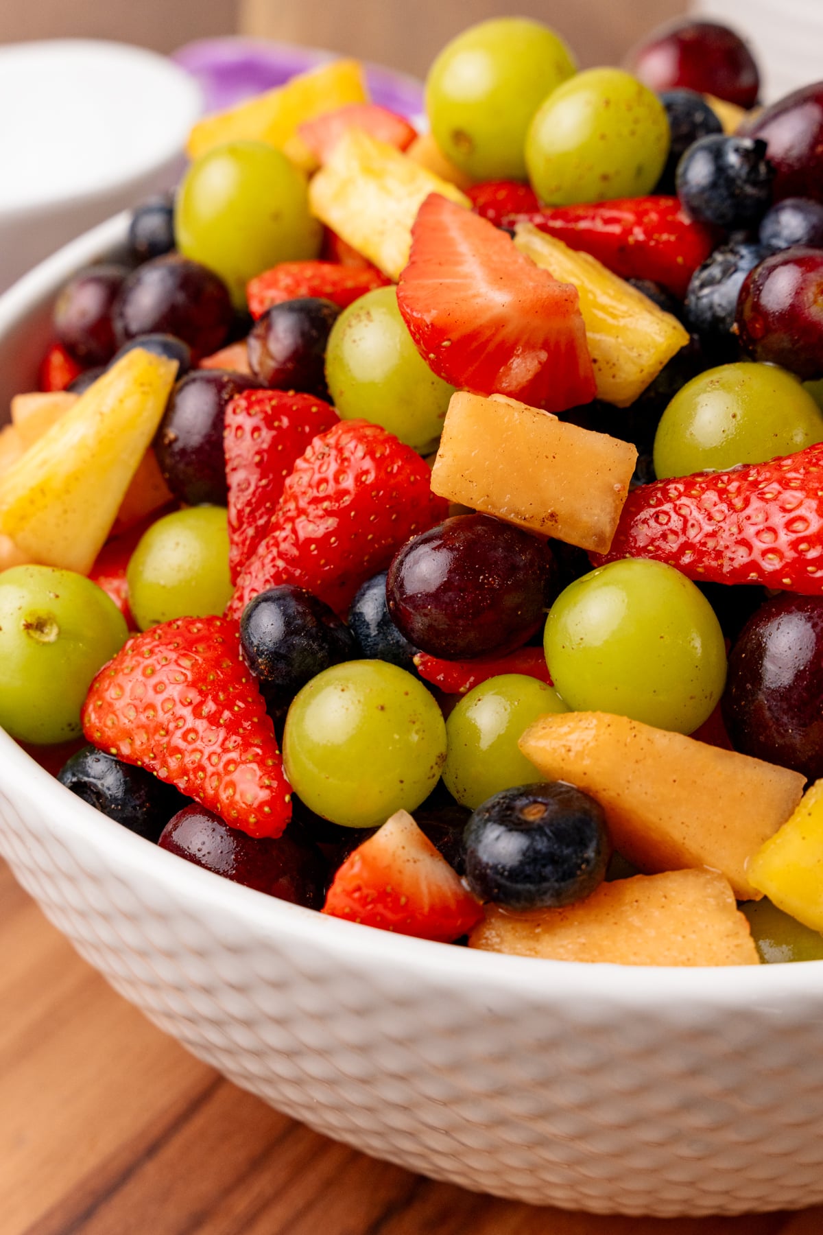 White serving bowl with fresh fruit salad.