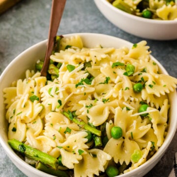 Bowl of lemon pasta salad with green peas and asparagus.