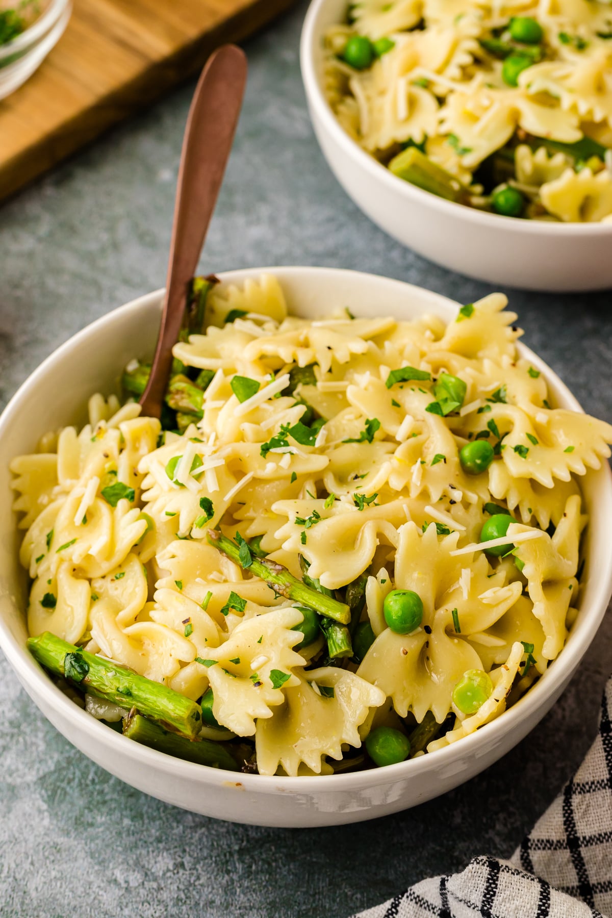 Bowl of lemon pasta salad with green peas and asparagus.