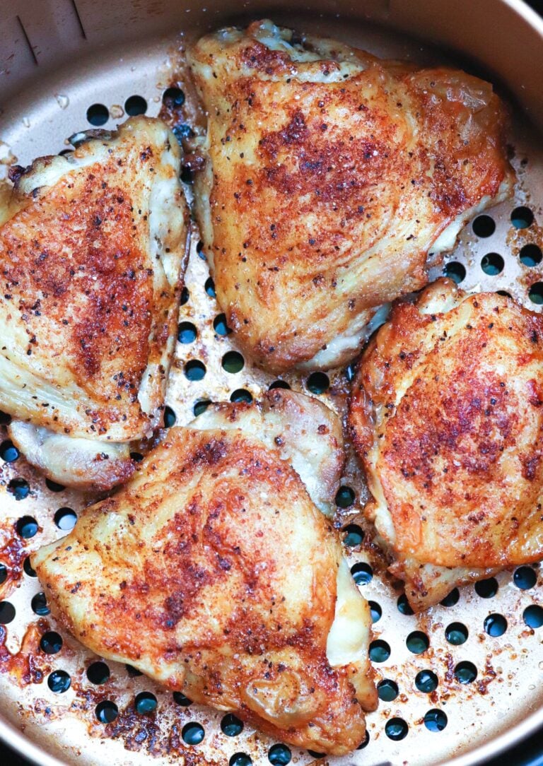 AF chicken copper1 thighs with paprika rub in copper pan with holes, overhead view showing golden-brown seasoned chicken pieces