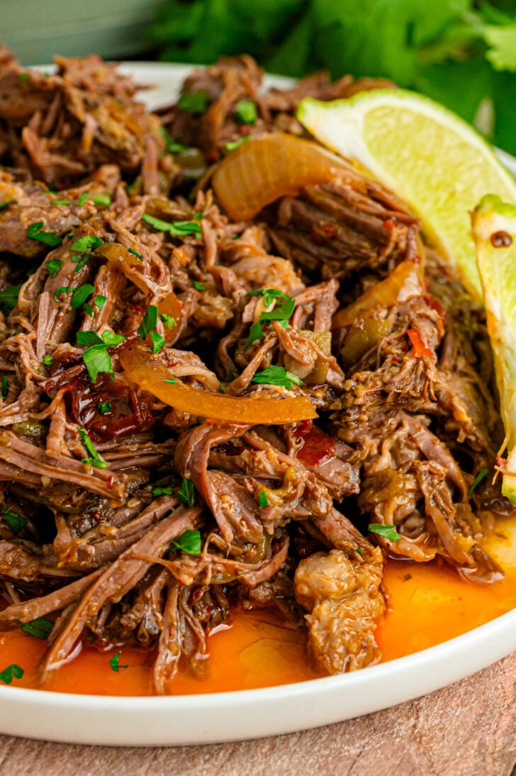 Crock Pot Mexican Shredded Beef is fall-apart tender with a deep, rich flavor. Made with chipotles, chiles, and a handful of warm spices, this simple recipe inspired by beef Barbacoa is fantastic for tacos, nachos, salads, and so much more!