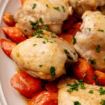Sheet Pan Honey Glazed Chicken Thighs with roasted red peppers garnished with fresh parsley on white plate