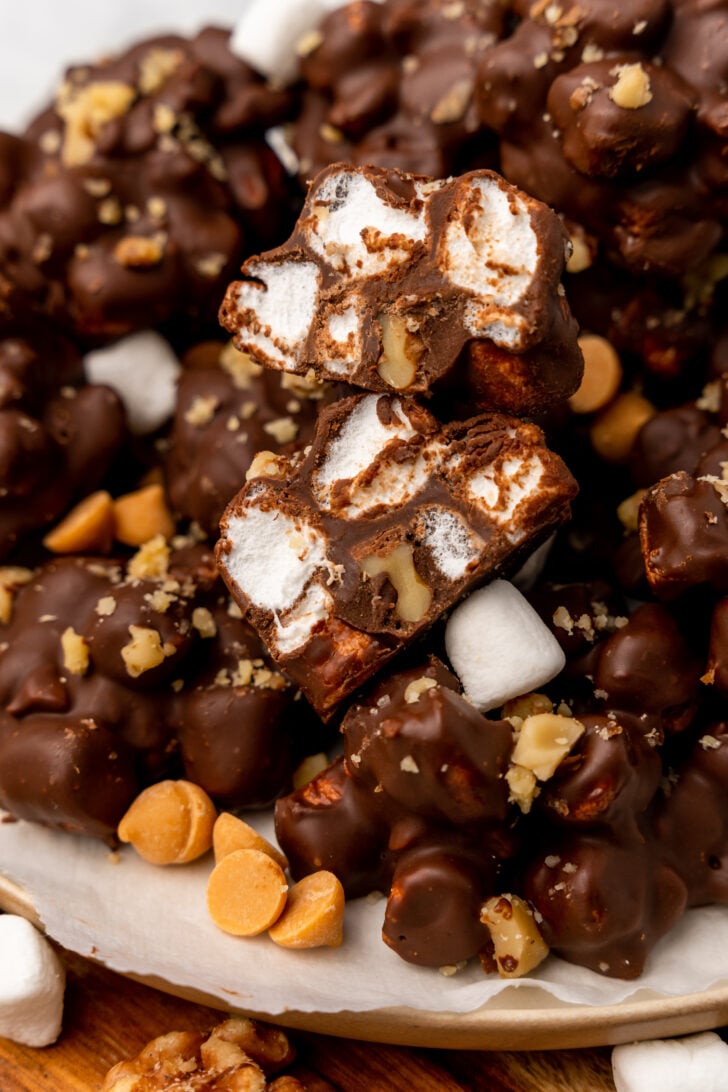 Rocky road candy clusters sitting in a cupcake wrapper cut in half exposing the butter scotch and marshmallow topping.