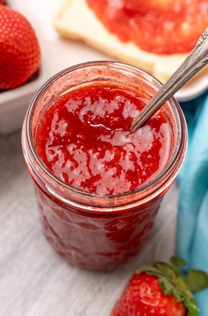 Glass jar full of homemade strawberry jam.