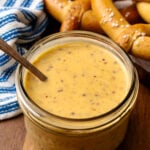 Honey mustard in a small glass jar served with a spoon.
