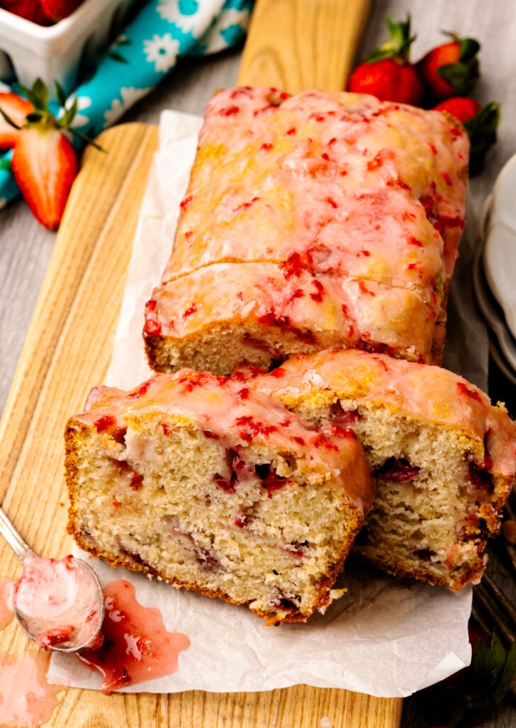Strawberry brad cross section with red strawberries on the inside and a delicious glaze ontop.