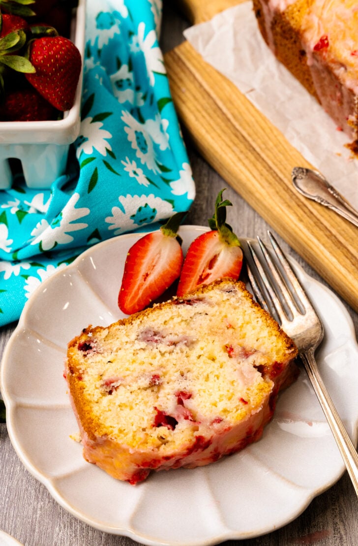 Strawberry brad cross section with red strawberries on the inside and a delicious glaze ontop.