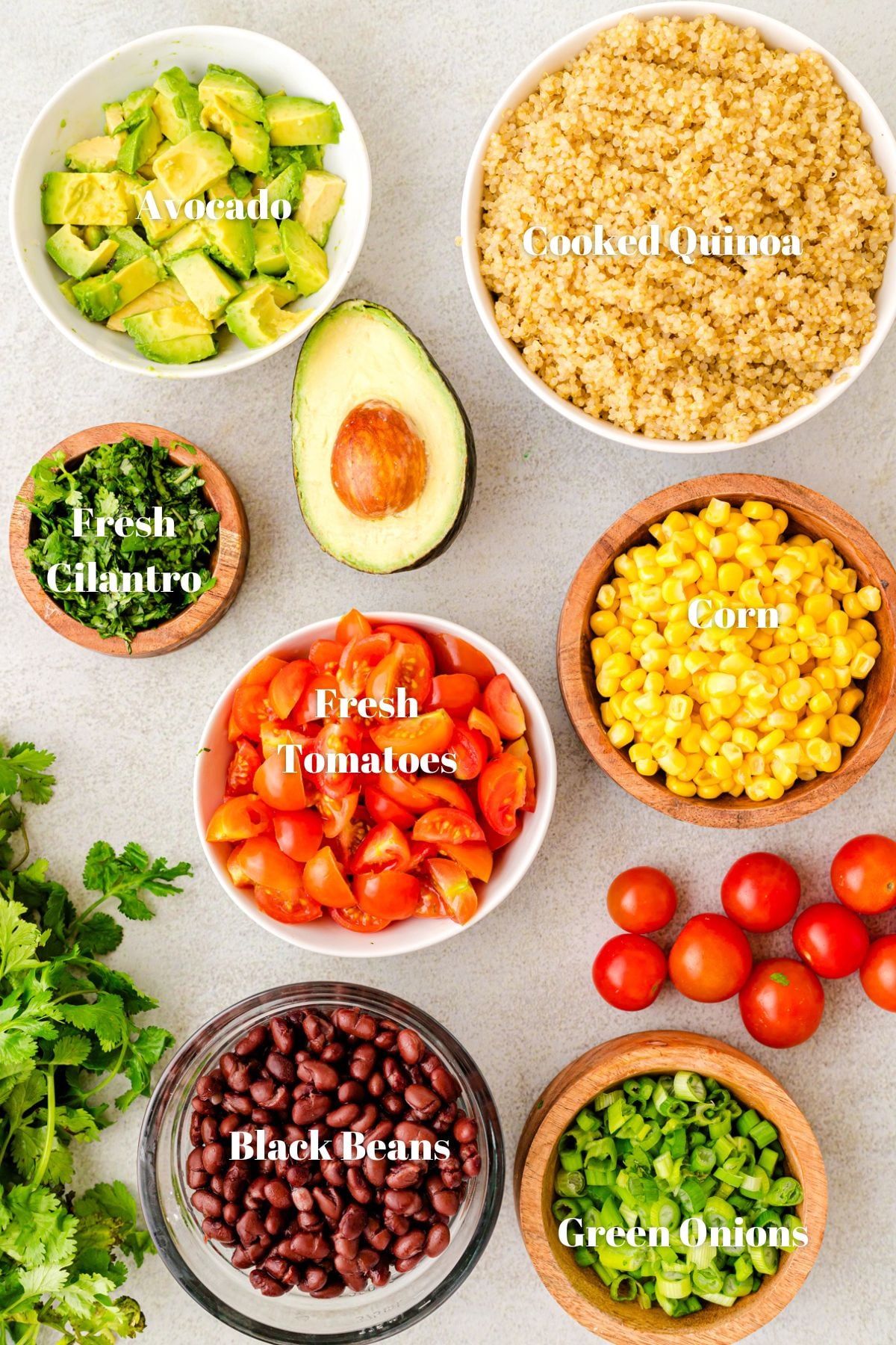 Ingredients to make quinoa salad. Fresh tomatoes, avocado, corn, green onions and black beans.