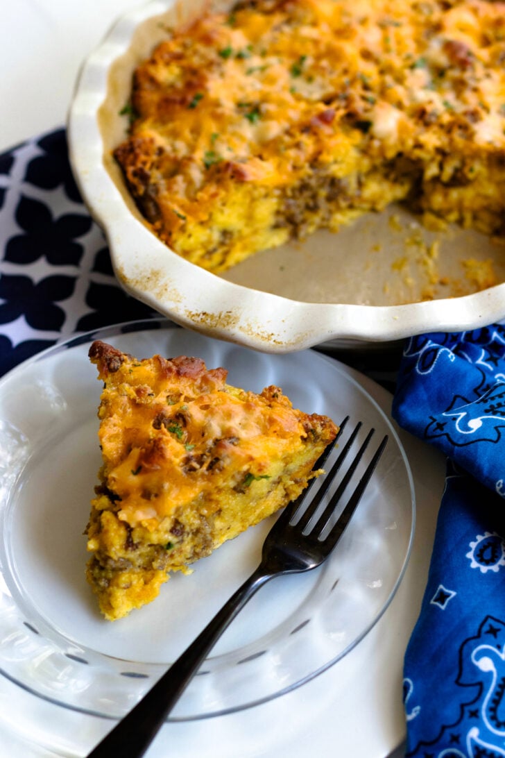 Quiche sitting in a pie dish, the cheese is perfectly melted and combines the sausage and eggs together.