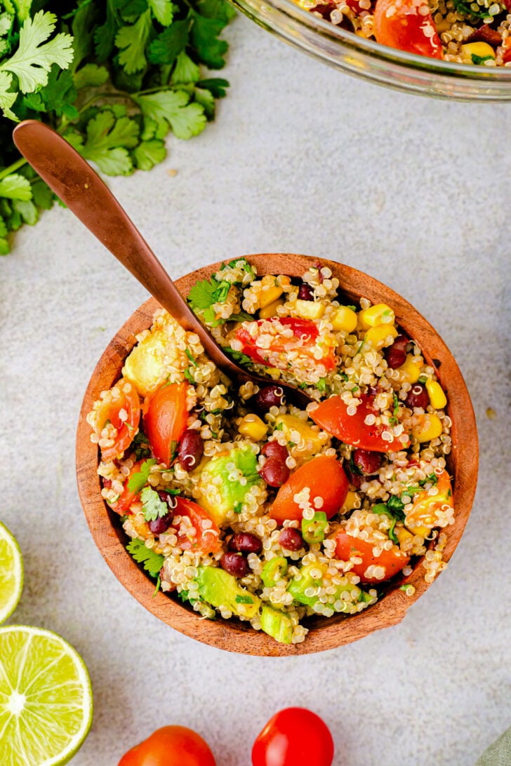 Fresh quinoa salad on a wooden spoon.