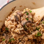 Creamy mushroom rice casserole served in a bowl with a spoon