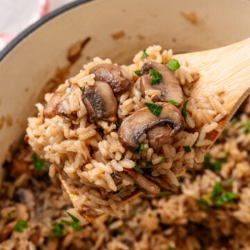 Creamy mushroom rice casserole served in a bowl with a spoon