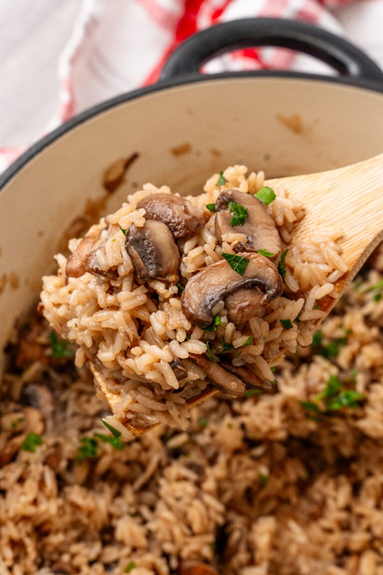 Creamy mushroom rice casserole served in a bowl with a spoon