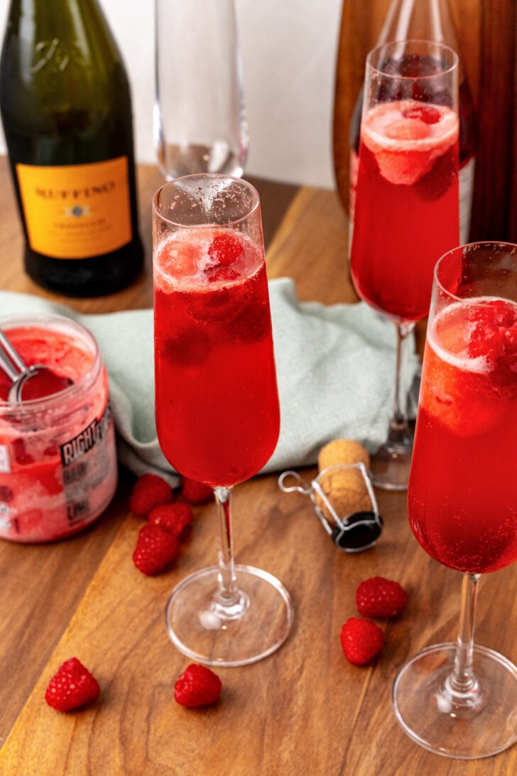 Glass with red raspberry mimosa with a layer of fizz on top.