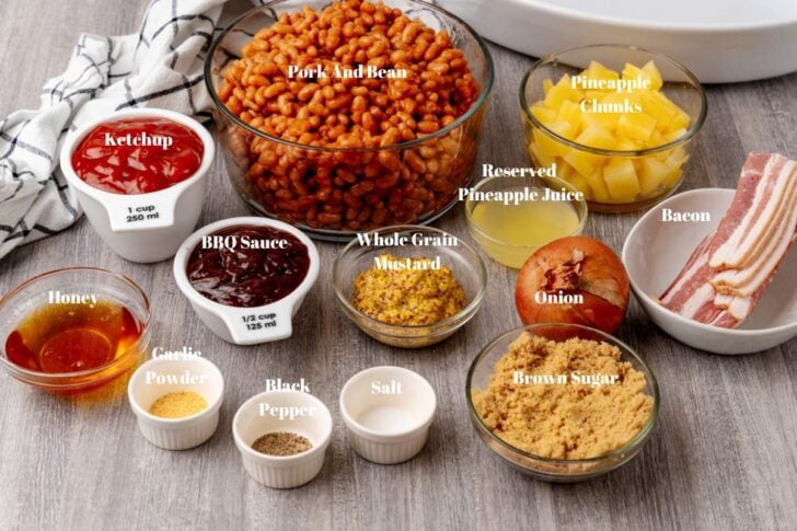 Ingredients in white or glass bowls for Pineapple BBQ Baked Beans.