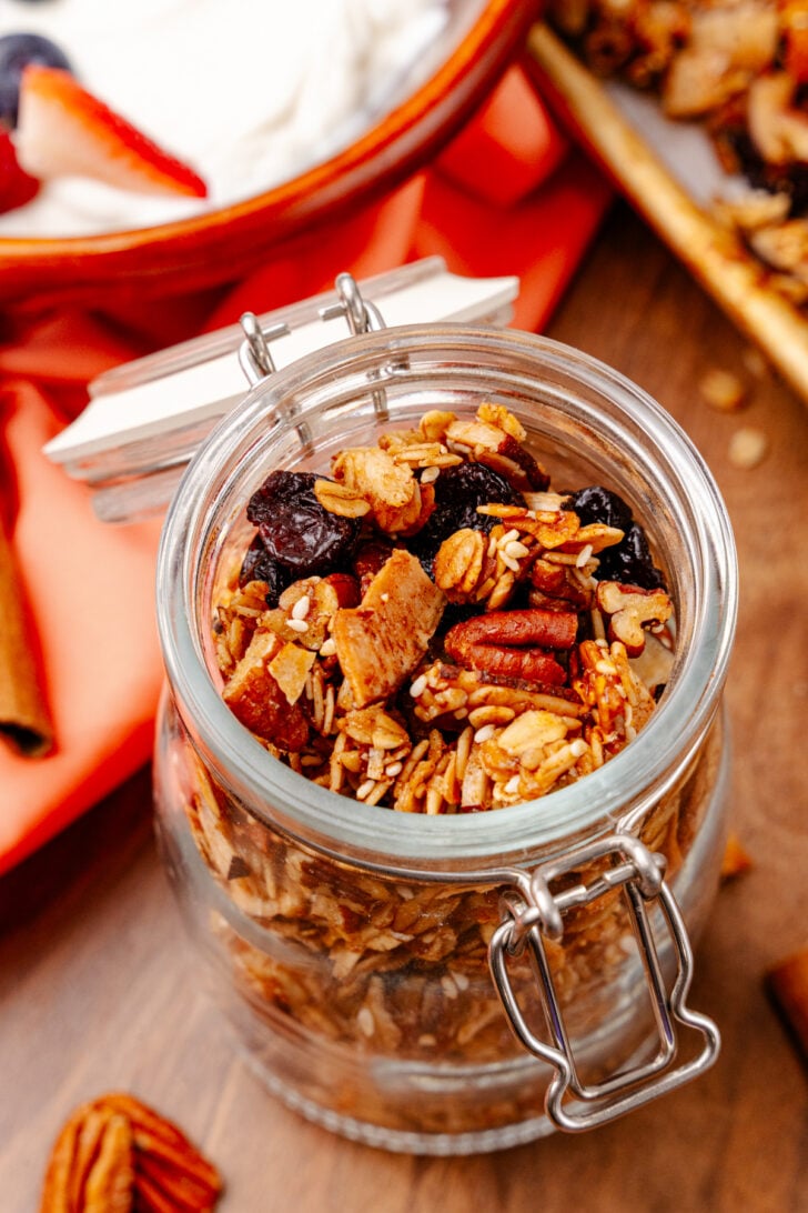 Easy Granola Homemade granola in a clear mason jar with its lid open.