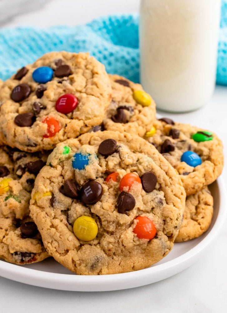 Monster cookies on a white plate served with milk.