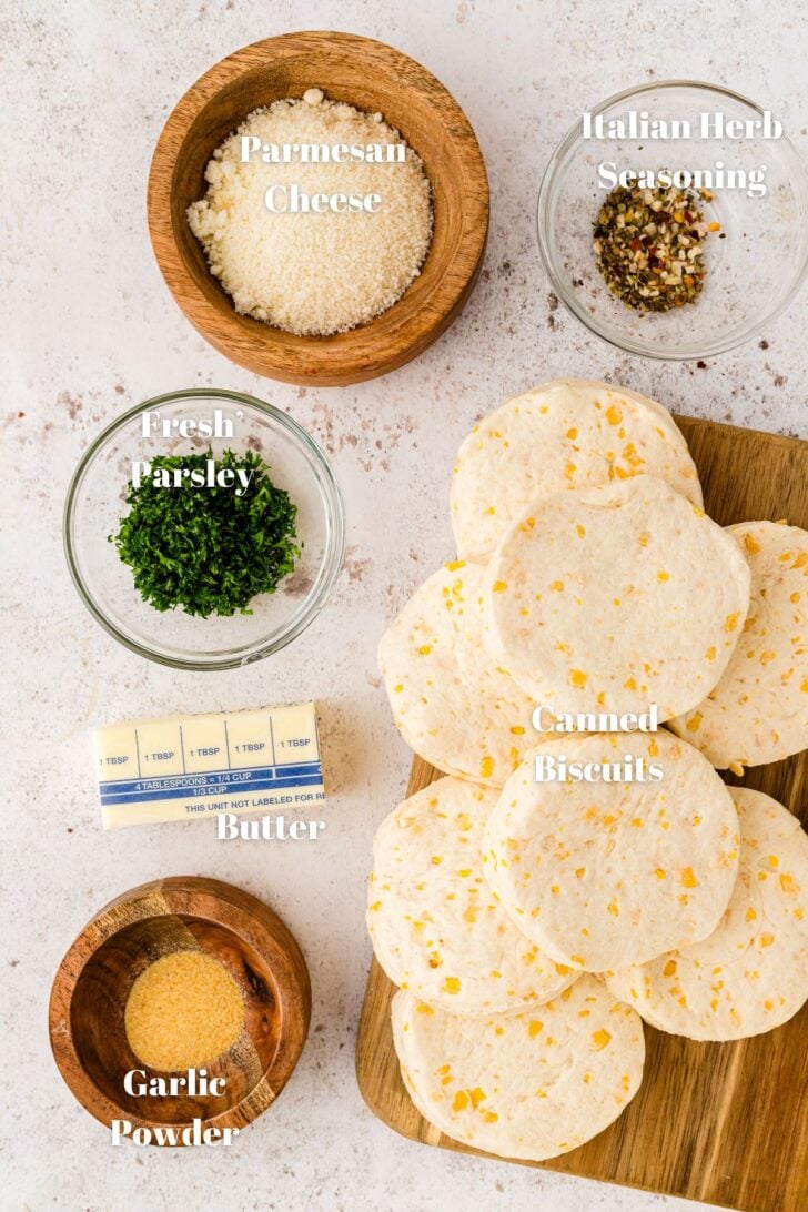 Canned biscuits, parmesan cheese, parsley and other ingredients for baked garlic knots.
