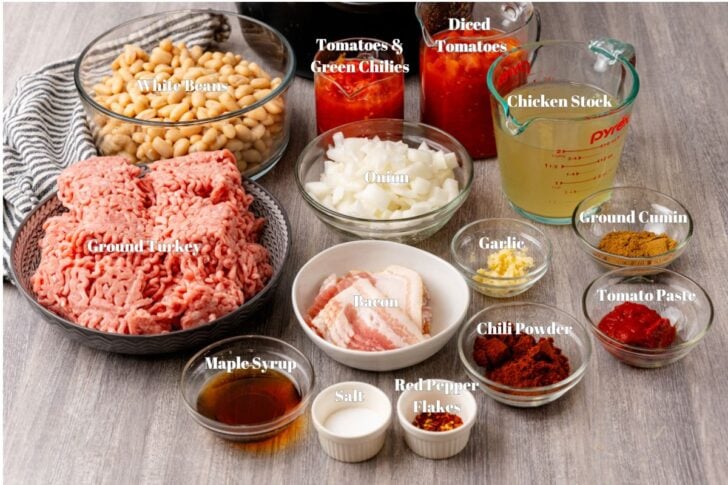 Ingredients for hearty turkey chili in glass containers on a counter.
