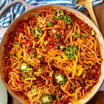 Cowboy Soaghetti made with ground beef bacon and other savory ingrediens topped with green onions and sliced jalapenos.