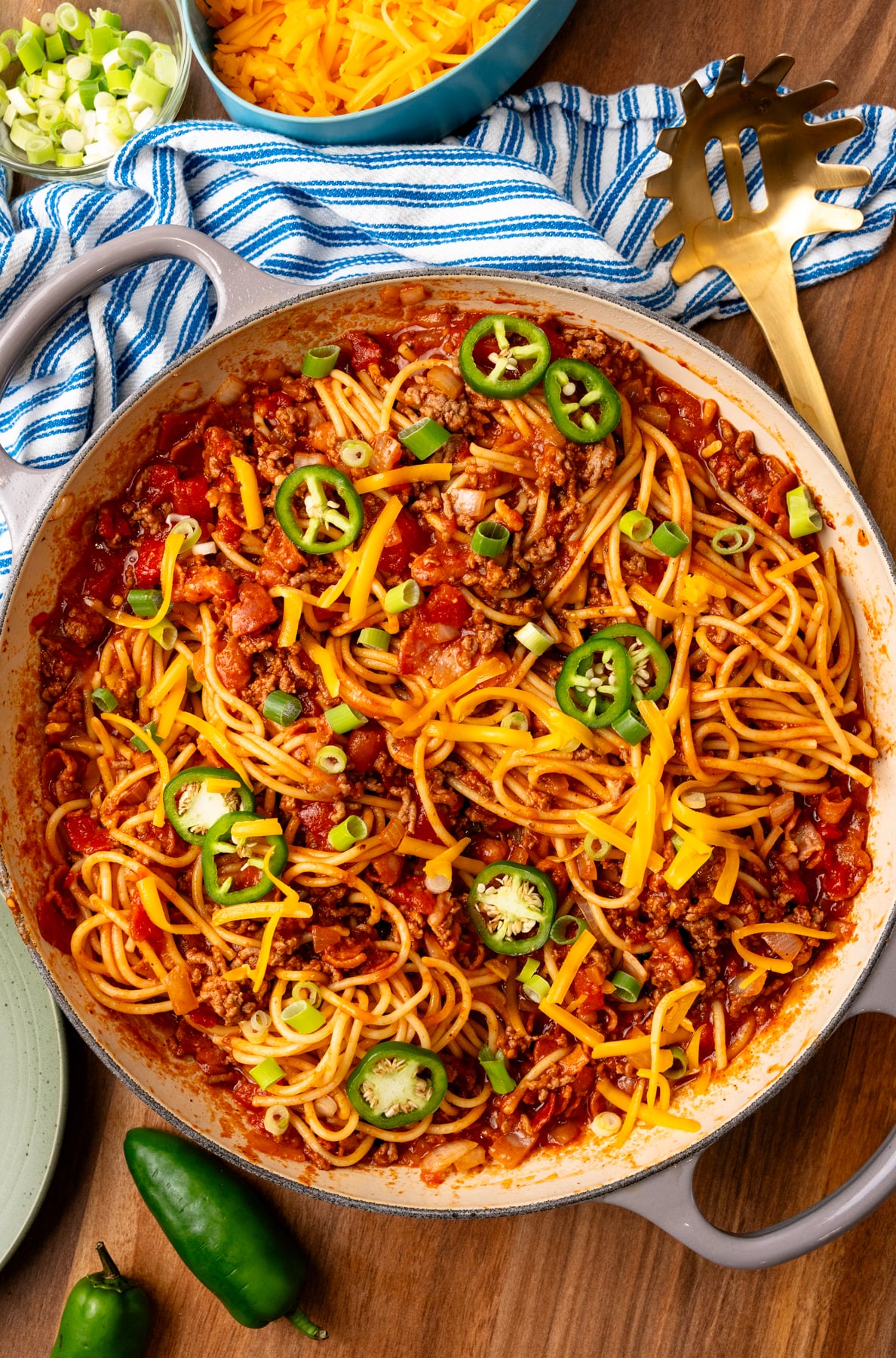 Cowboy Soaghetti made with ground beef bacon and other savory ingrediens topped with green onions and sliced jalapenos.