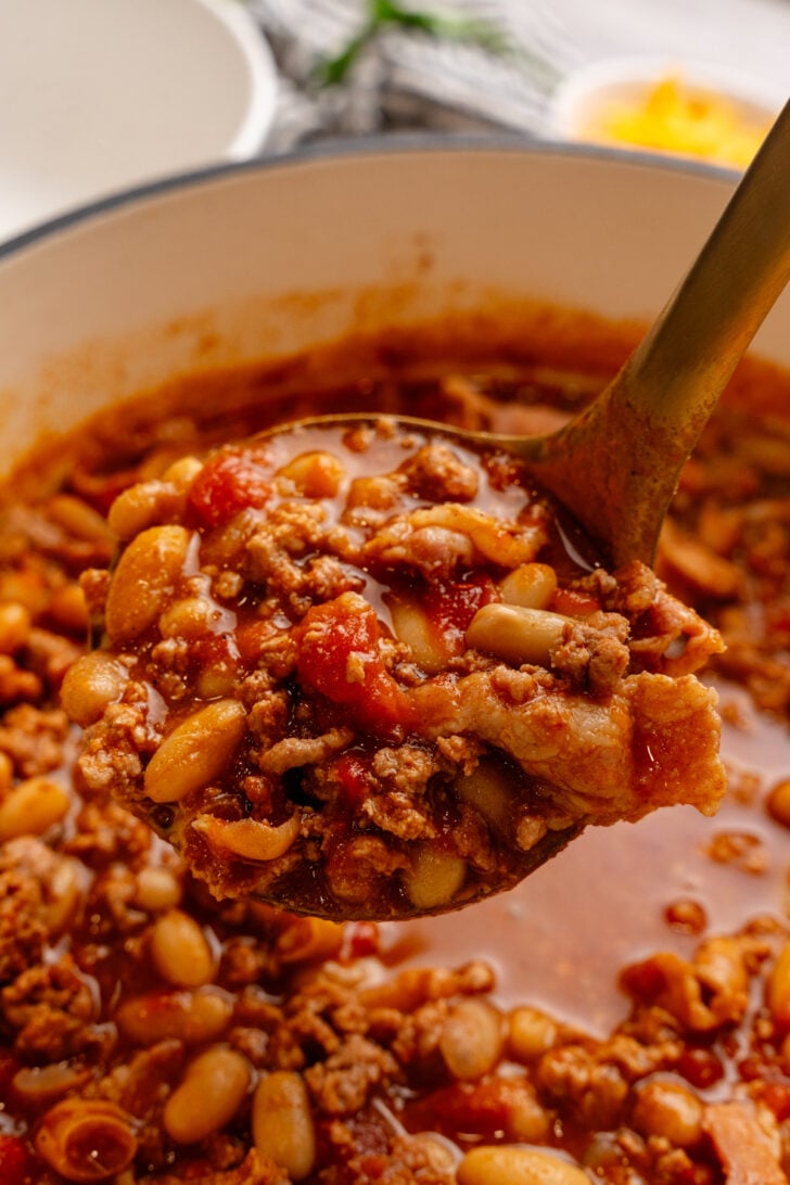 Metal ladle full of hearly turkey chili.