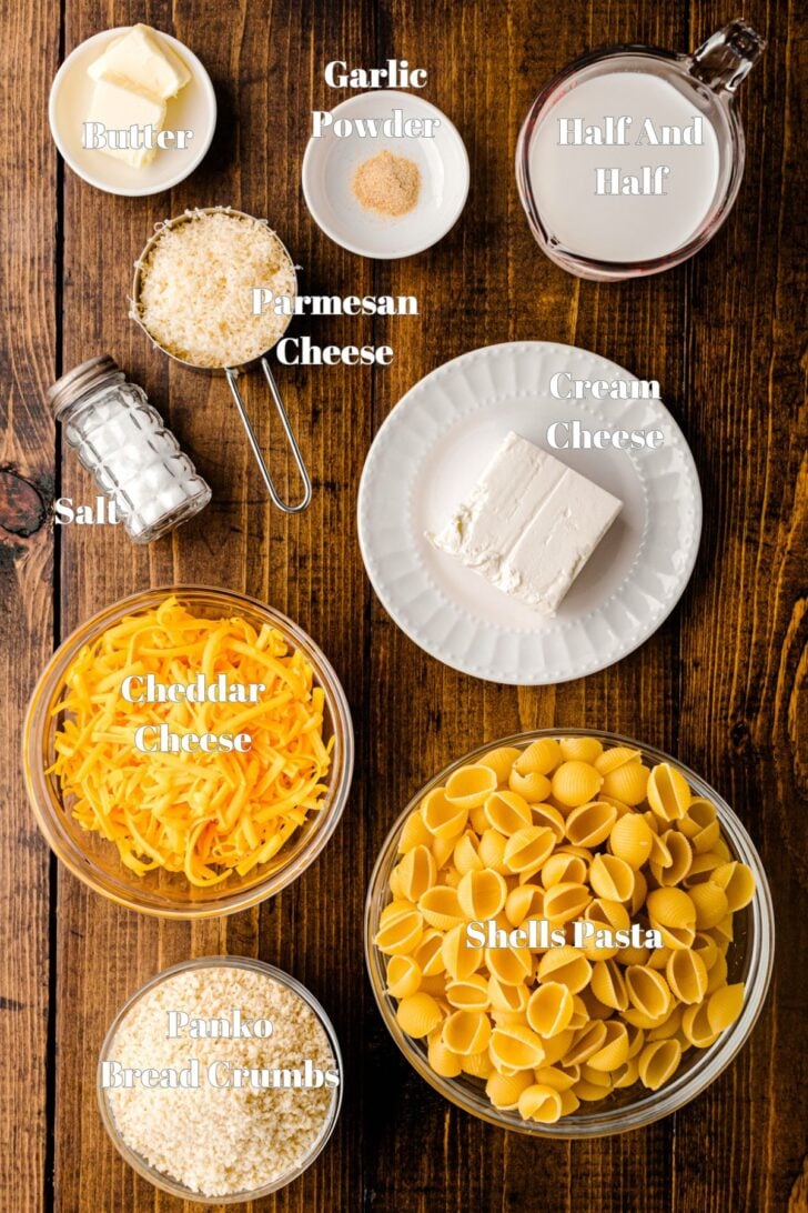 Ingredients for creamy Shells and Cheese in containers on a wooden table.