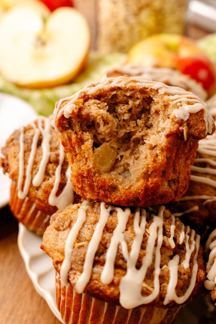 Fresh-baked Honeycrisp apple muffins with cinnamon and maple syrup glaze stacked on a plate.