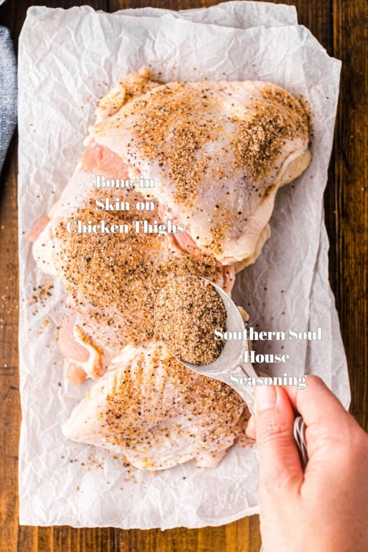 Chicken thighs on parchment paper sprinkled with Southern Soul House Seasoning.