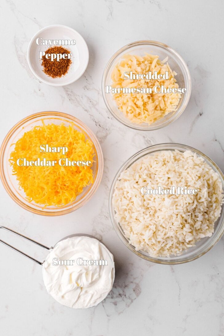 Rice, cheese, sour cream and seasoning in glass bowls for cheesy rice recipe.