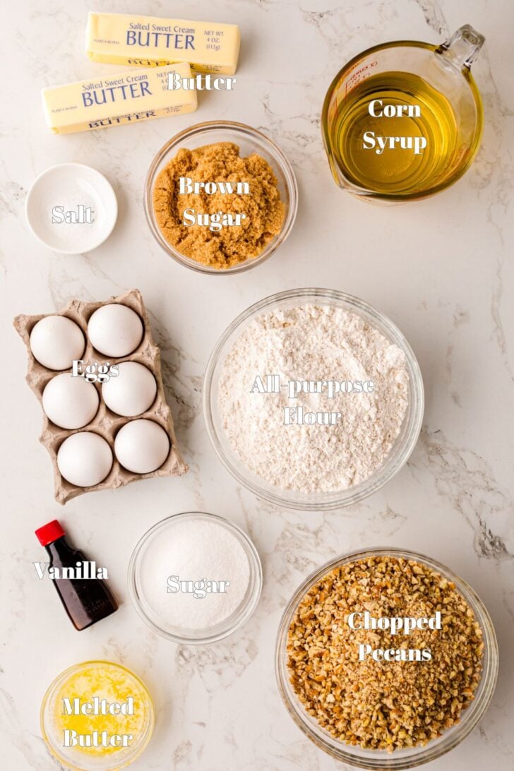 Ingredients in glass bowls on a white counter for Southern Style Pecan Pie Bars.