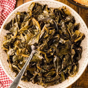 Collard greens 7 served in a cream-colored bowl with a spoon, cornbread in cast iron skillet, red gingham cloth, wooden table