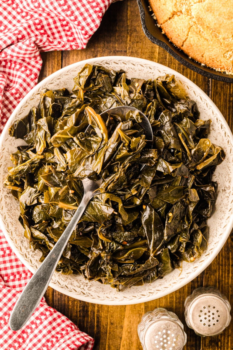 Collard greens 7 served in a cream-colored bowl with a spoon, cornbread in cast iron skillet, red gingham cloth, wooden table
