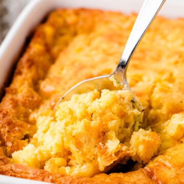 Cornbread pudding with cheese served with a spoon for the holidays.