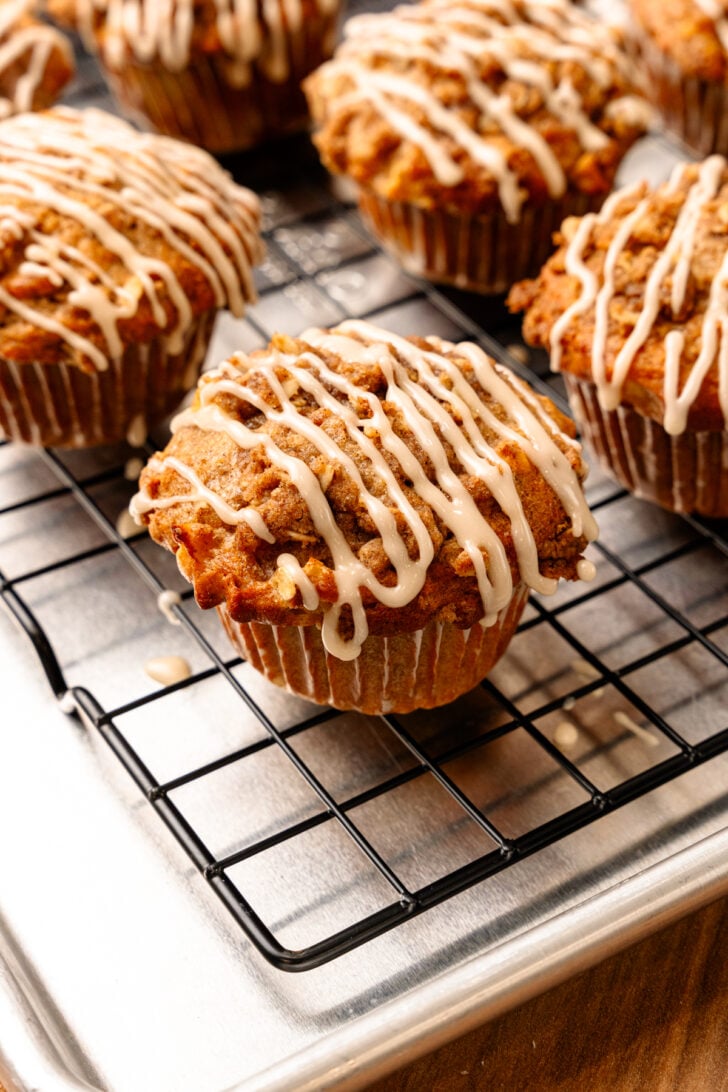 Honeycrisp muffins with maple glaze on a cooling rack.