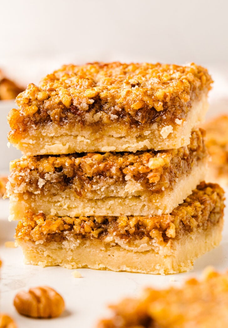 Southern Style Pecan Pie bars but and stacked on top of each other and ready for serving.
