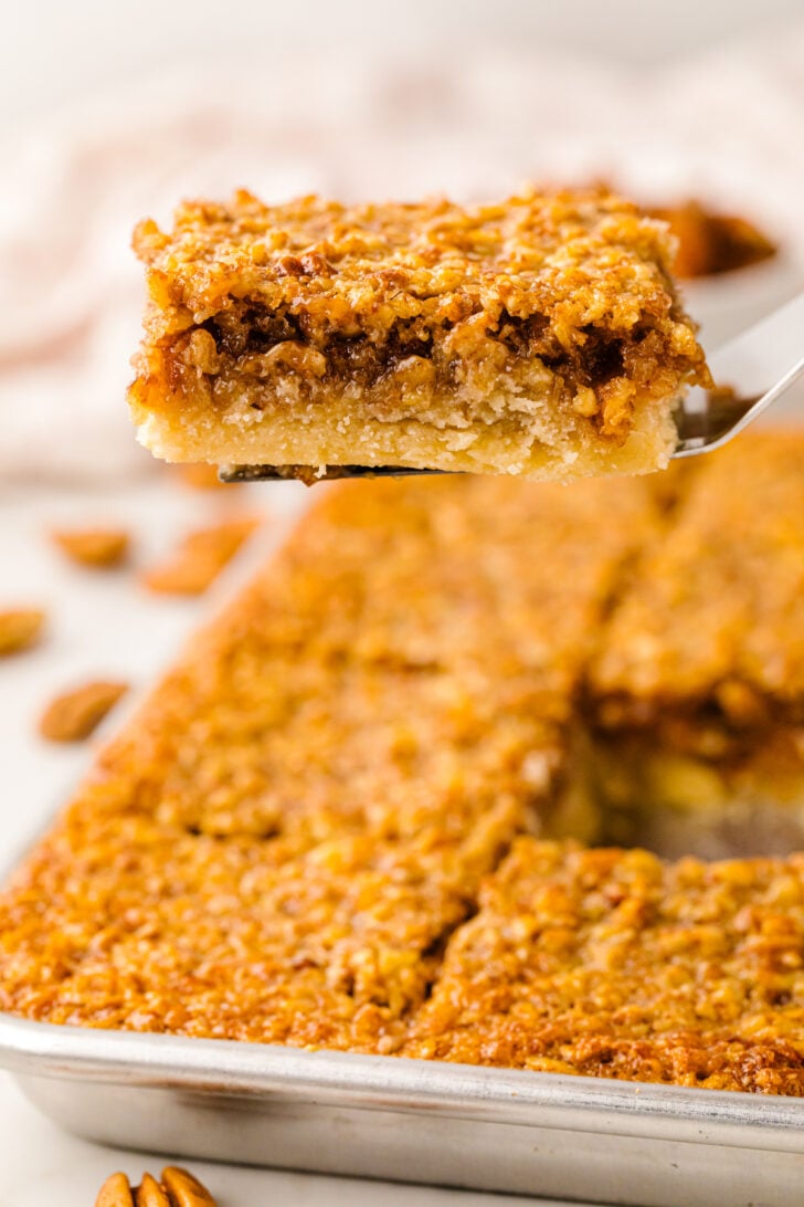 Sliced pecan pie bar sliced and served on a spatula.
