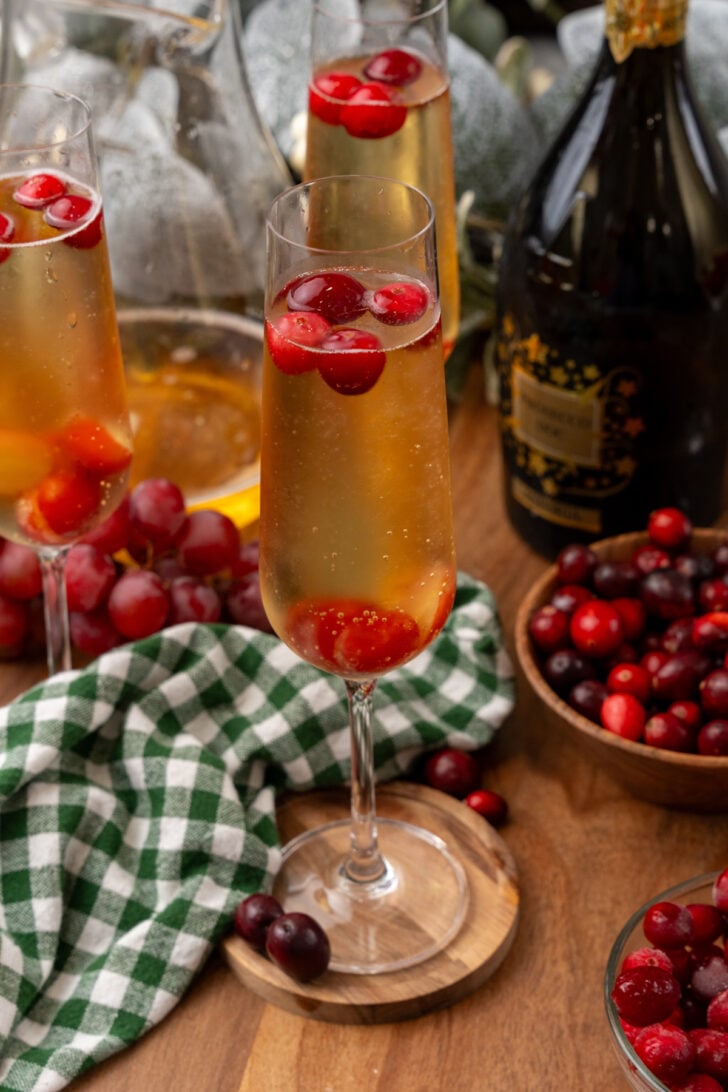 Mistletow Mimosas served with cranberry and grapes as a garnish.