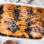 Make-Ahead Pancake Casserole: Easy, Fluffy, and Delicious baked in white dish with sliced apples, blueberries, and powdered sugar
