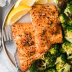 Plated airfryer salmon 10 e1755524148211 with crispy blackened seasoning, roasted broccoli, and lemon wedges on ceramic dish with fork
