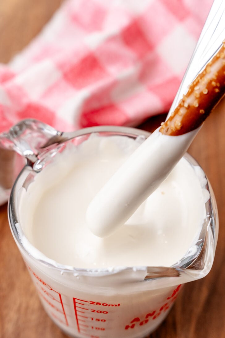 Melted white chocolate and a pretzel rod to make Valenntines Day pretzels.