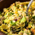 Avocado chicken salad 4 with corn and herbs served in a wooden bowl with a serving spoon