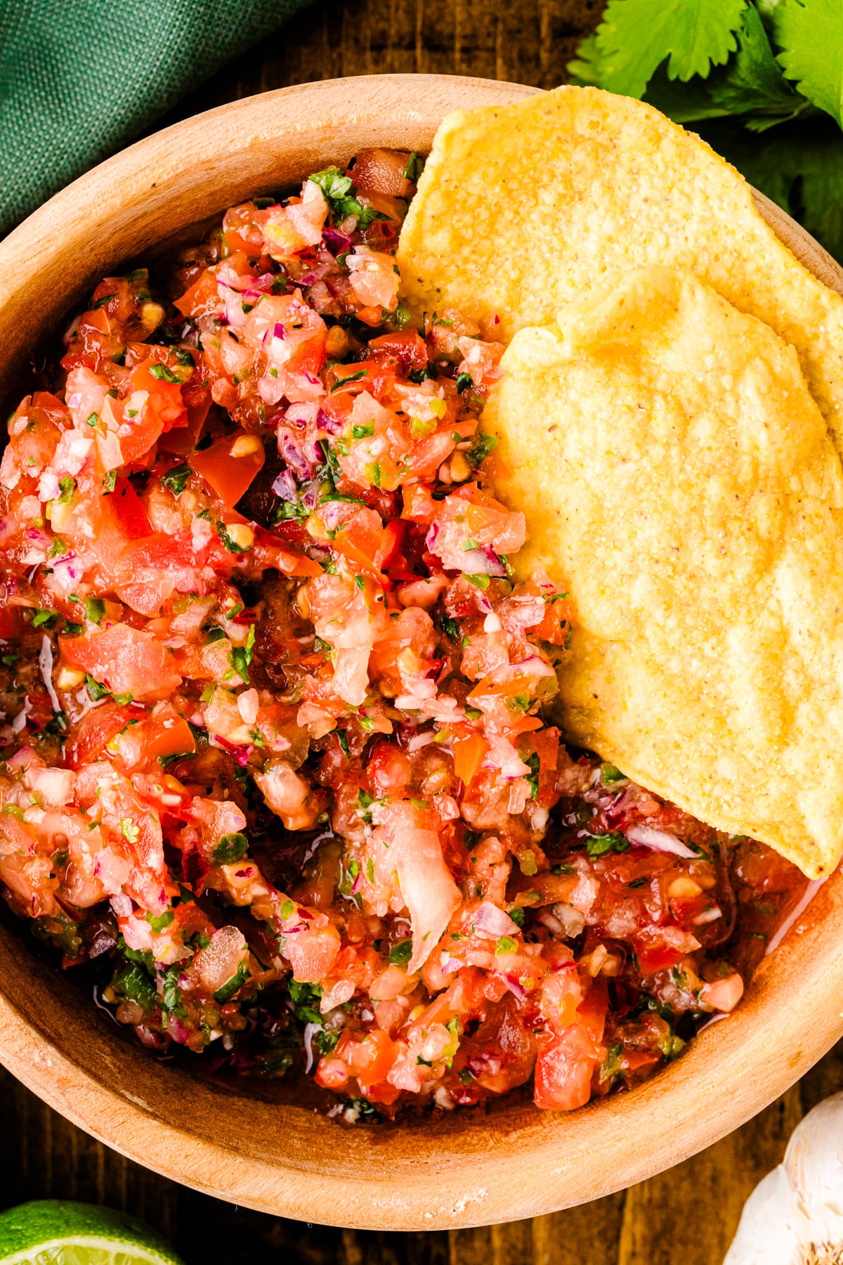 Fresh 5min salsa 6 in wooden bowl with tortilla chips, cilantro garnish, overhead view on dark wood background