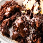 Southern Chocolate Cobbler with vanilla ice cream served in a white bowl with a spoon on marble surface