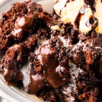 Southern Chocolate Cobbler with vanilla ice cream served in a white bowl with a spoon on marble surface