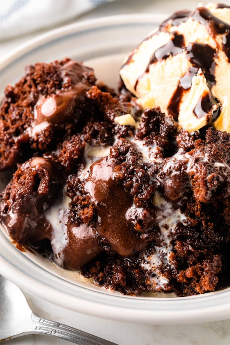 Southern Chocolate Cobbler with vanilla ice cream served in a white bowl with a spoon on marble surface