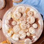 Southern Coffee Punch dessert in clear bowl topped with whipped cream piped rosettes and cinnamon, served with glasses on wooden table