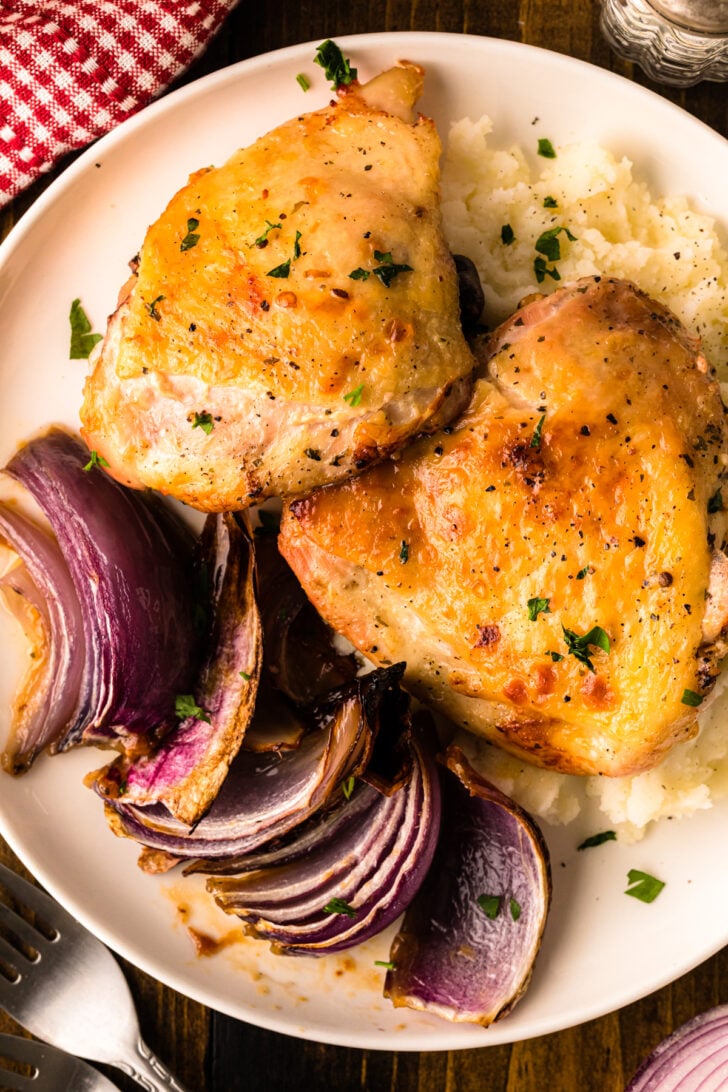 Baked Ranch Chicken – Sheet Pan Recipe with golden chicken thighs, roasted red onions, and mashed potatoes on white plate