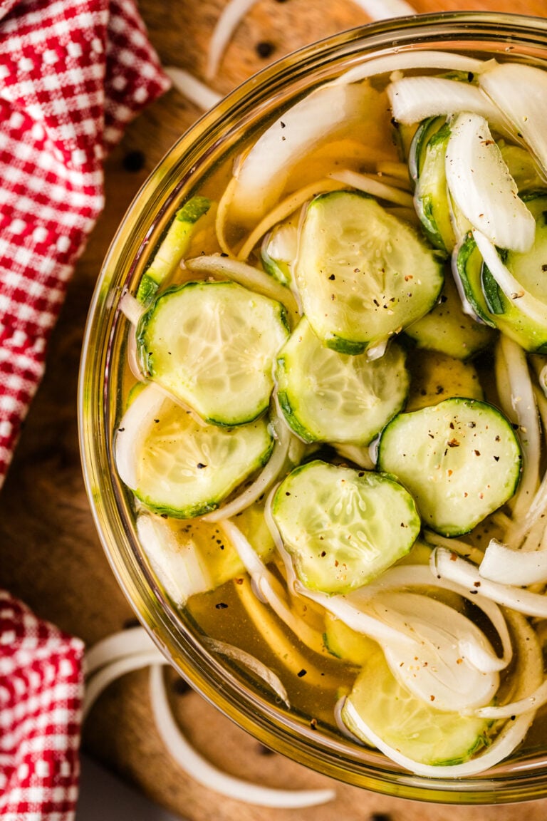 Homemade refrigerator pickles 7 with sliced cucumbers and onions in a glass jar with brine and black pepper